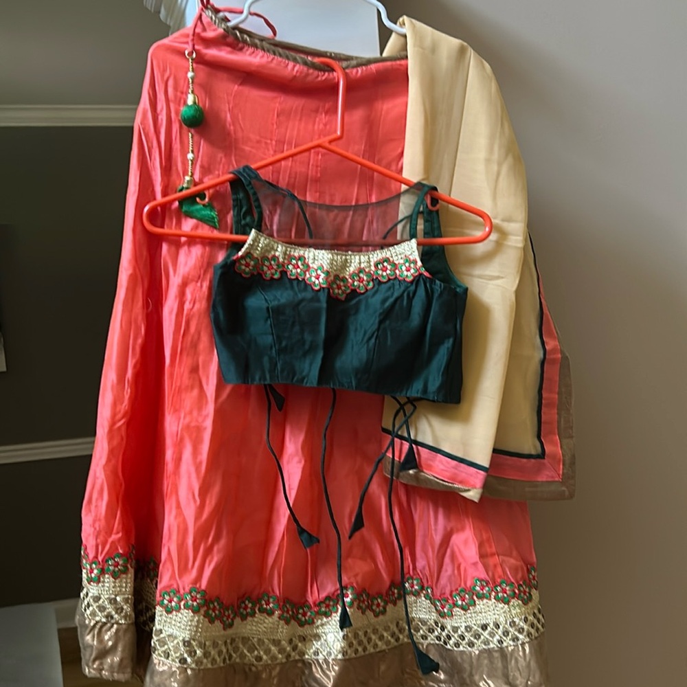 Blouse in dark green chaniya in peach color dupatta in light peach color .